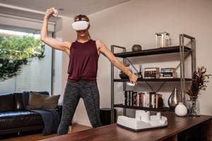 Woman dancing with Oculus Quest 2, with Player Bounty Charging Dock nearby